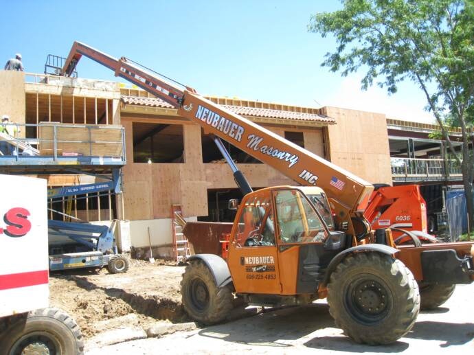 Neubauer Masonry Lull telehandler working on a job site with boom extended