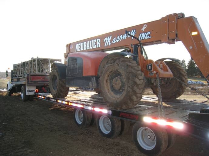 Neubauer Masonry telehandler being transported on trailer